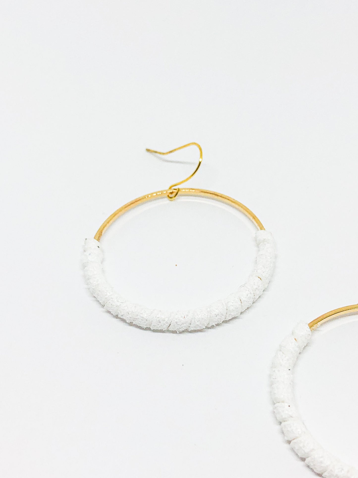 Gold hoop earrings with white faux suede