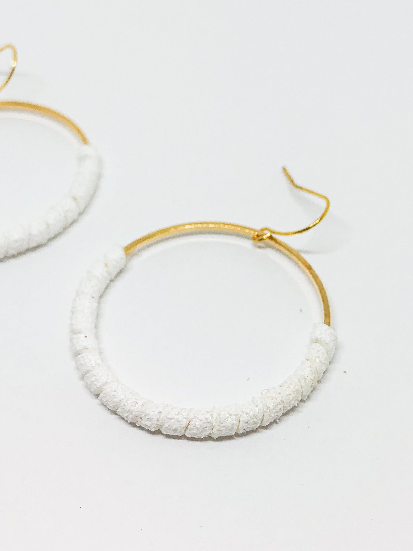 Gold hoop earrings with white faux suede