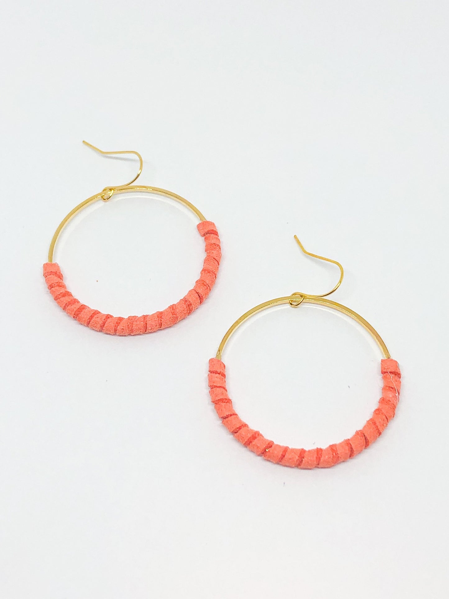 Gold hoop earrings with coral faux suede