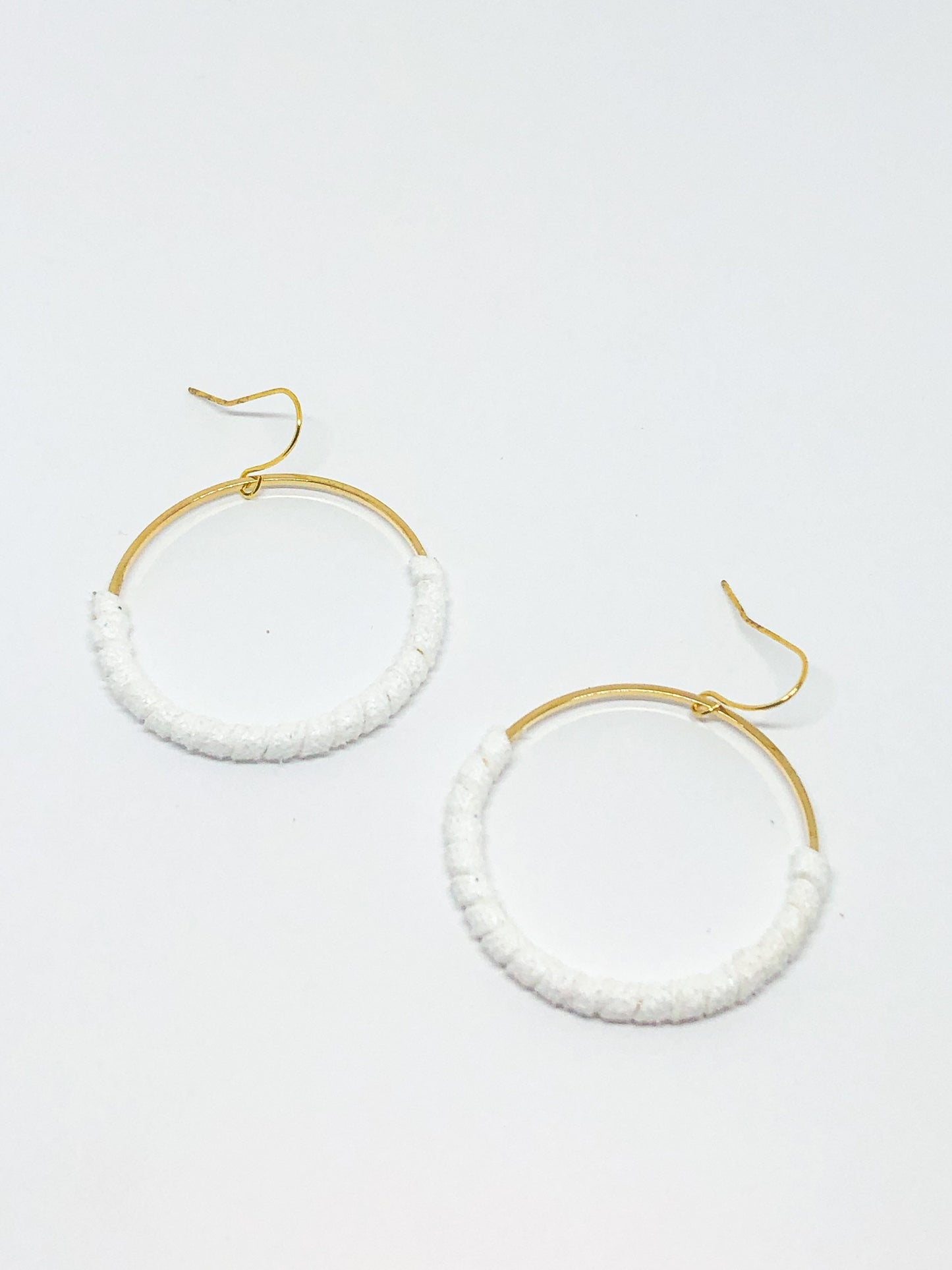 Gold hoop earrings with white faux suede